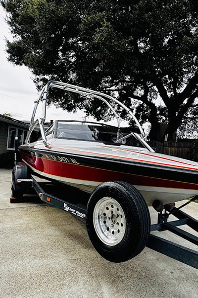 Black and red striped boat after professional mobile detailing showing restored gel coat shine Bay Area
